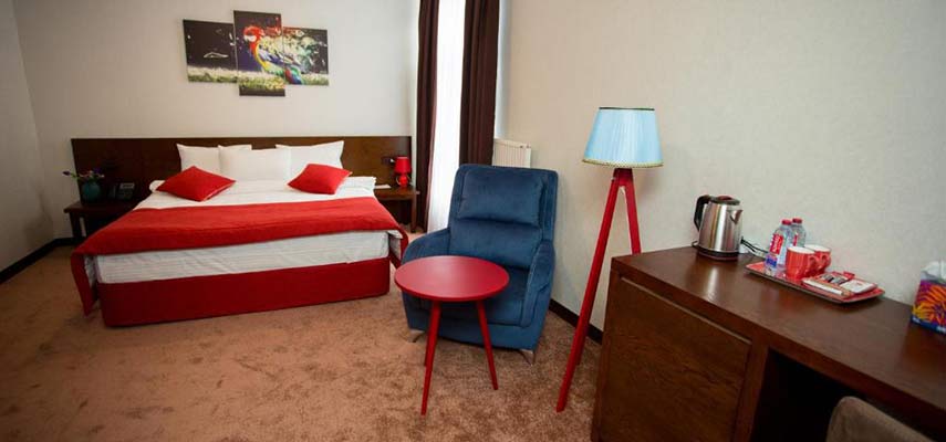 double bedroom with red colours and desk in view